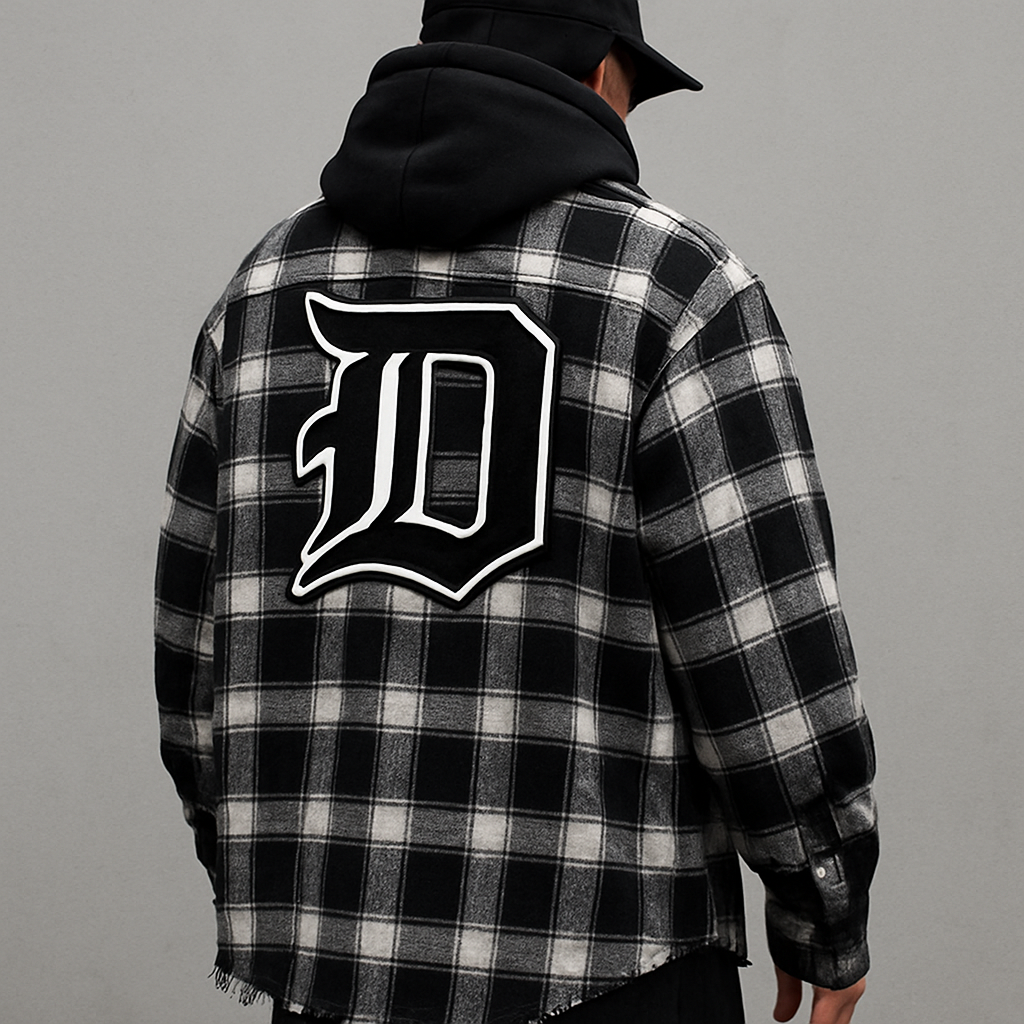 I have a clothing line called da Motion dept. I want the D’s to be the Detroit old English d I also want a amiri,offwhite type style I make custom flannels, varsity jackets with big patches on the back 

Streetwear fashion design: **Prompt:** A dMtn Dept. (Detroit Old English 'D') Amiri/Off-White style streetwear look. Oversized cotton flannel, black and white plaid, raw hem. Relaxed fit. Back features a large varsity patch.