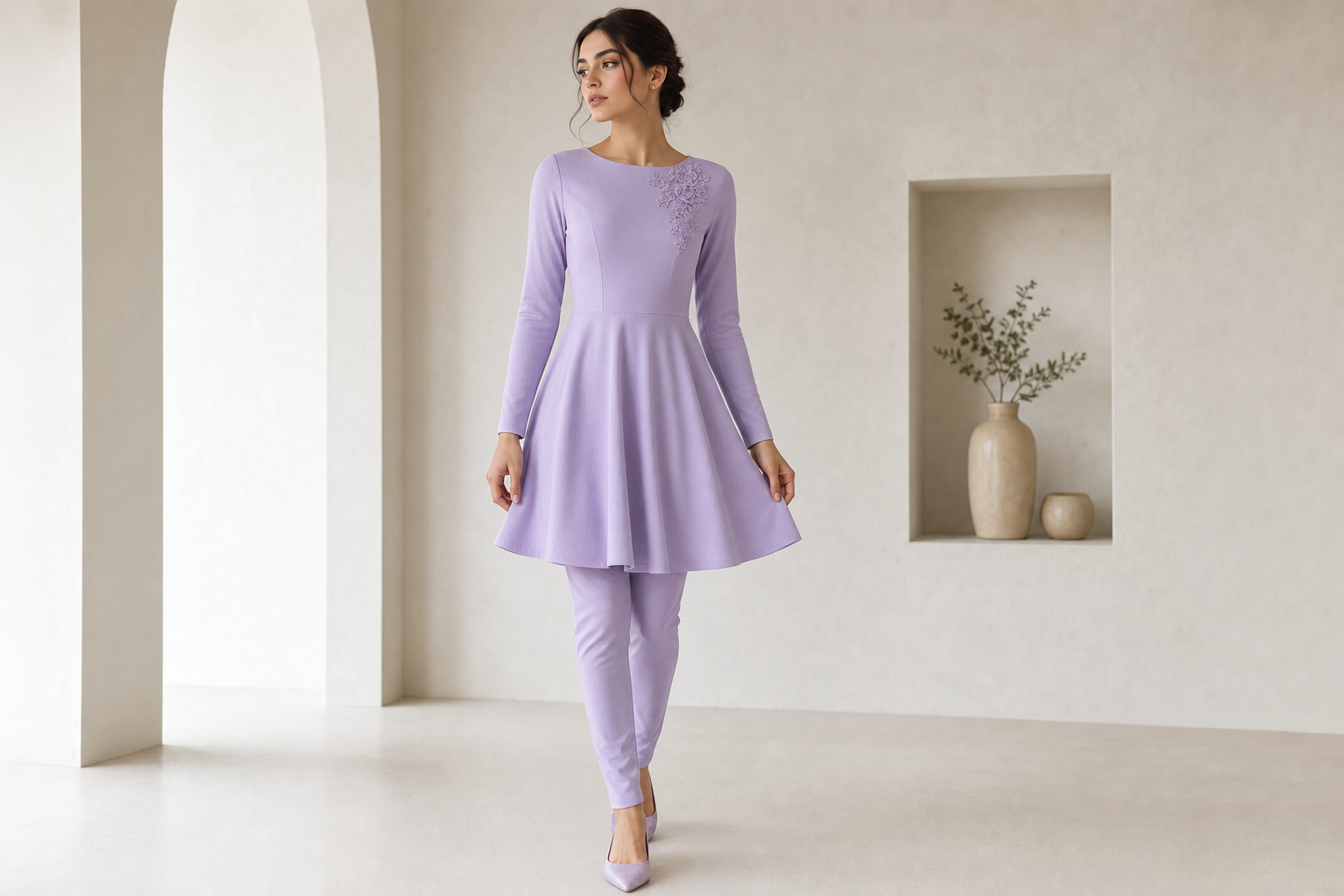 Lavender short dress tight on top and loose on the bottom with long sleeve. Little lavender lace flower on top right hand corner. Long pant tight leggings underneath dress.
Contemporary fashion design: Lavender cotton short dress: fitted bodice, flowing skirt, long sleeves. Modern, minimalist silhouette. Small lavender floral lace detail at top right. Tailored lavender cotton leggings underneath.