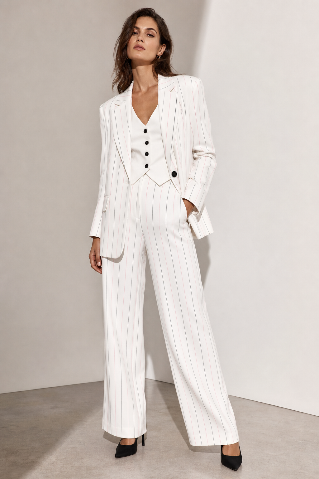 White pant suit with black and pink pin stripes. White vest underneath with black buttons. Black high heel.
Contemporary fashion design: Clean-cut white pantsuit with a relaxed fit. Subtle black and pink pinstripes. Worn with a simple white vest, featuring understated black buttons. Paired with classic black high heels.