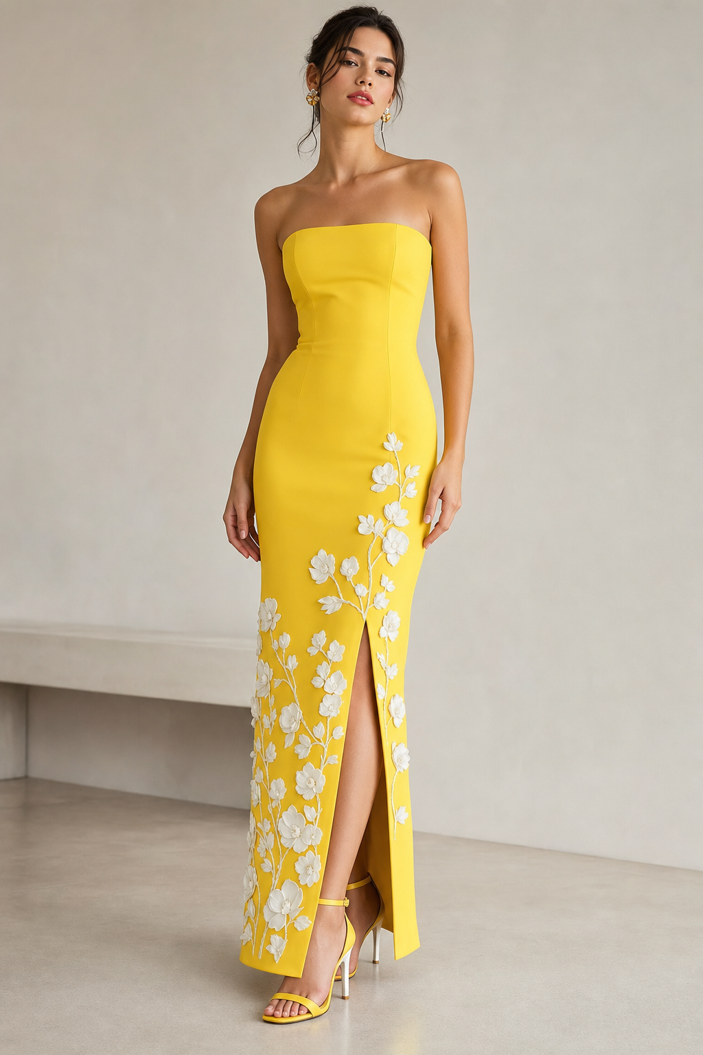 Bright yellow long tight strapless dress. Tight on top and bottom and 3-d white flowers on bottom half of dress. Slit in front of dress. Bright yellow high heel with white heel.
Contemporary fashion design: Bright yellow strapless column dress. Form-fitting, with a front slit. Features subtle 3D white floral appliques on the lower half. Paired with bright yellow high-heeled sandals with white heels. Minimalist.